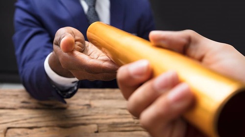 Businessman Passing Baton To His Partner