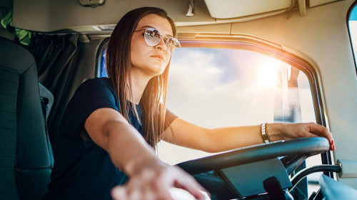 Portrait of beautiful young woman professional truck driver sitt