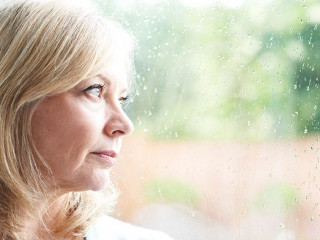 Sad Mature Woman Suffering From Agoraphobia Looking Out Of Windo