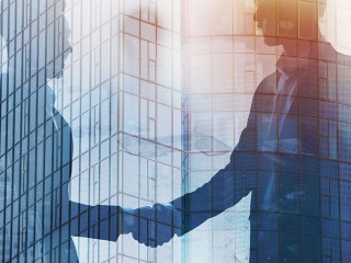 Handshaking business person in office. concept of teamwork and partnership. double exposure