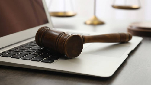 Laptop, gavel and scales on table, closeup. Cyber crime