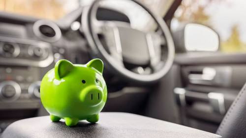 Green piggy bank money box inside car, vehicle purchase, insuran