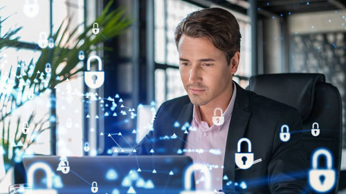 Handsome businessman in suit at workplace working with laptop to defend customer cyber security. Concept of clients information protection and brainstorm. Padlock hologram over office background.