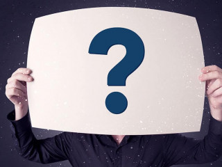 Businessman holding paper with question marks