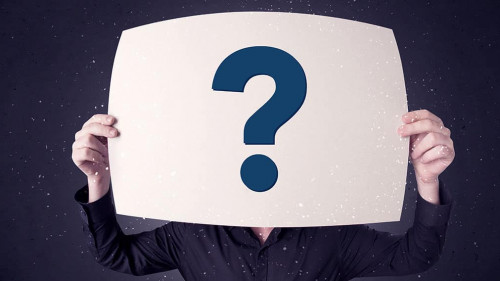 Businessman holding paper with question marks