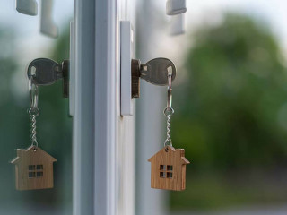 The wooden house key is inserted at the door of the house. There