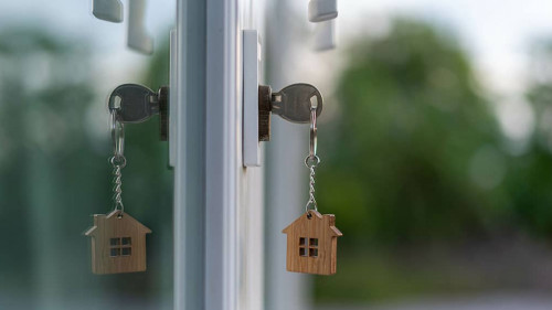 The wooden house key is inserted at the door of the house. There