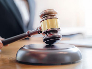 Woman judge hand holding gavel to bang on sounding block in the