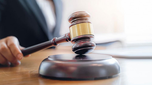 Woman judge hand holding gavel to bang on sounding block in the