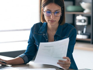 Pretty young business woman working with computer while consulti