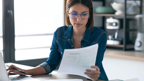 Pretty young business woman working with computer while consulti