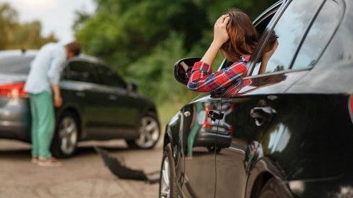 Male and female drivers after car accident on road
