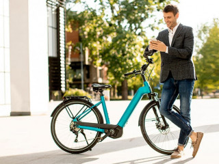 Young businessman on the ebike using mobile phone