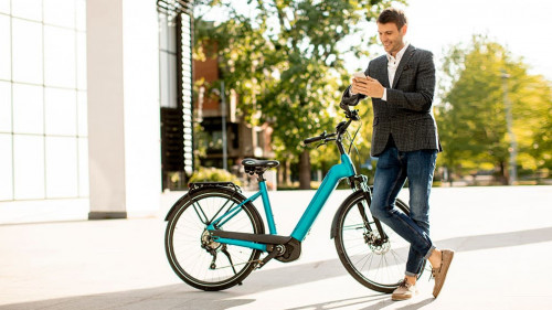 Young businessman on the ebike using mobile phone