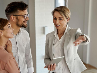 Happy real estate agent showing to a couple their new home.