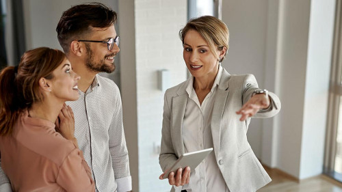 Happy real estate agent showing to a couple their new home.