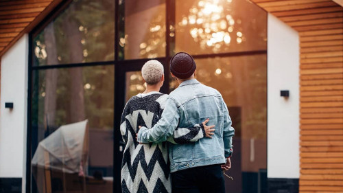 Happy young married couple look at their house