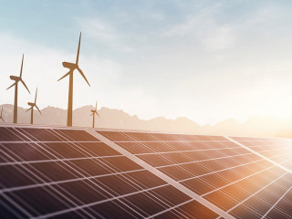 solar panels and wind power turbines in a sunset