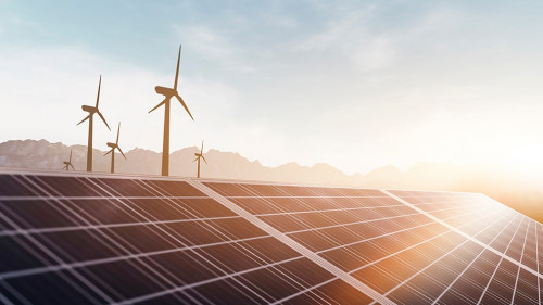 solar panels and wind power turbines in a sunset