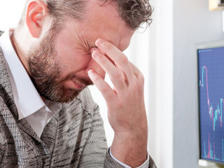 Depressed investor analyzing crisis stock market with graph on s