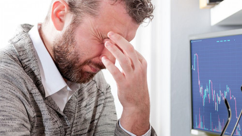 Depressed investor analyzing crisis stock market with graph on s