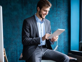 Handsome elegant businessman working on a tablet.