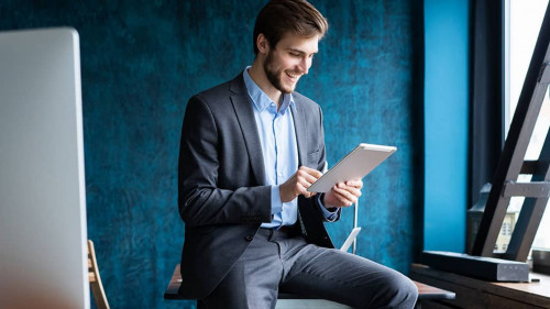 Handsome elegant businessman working on a tablet.