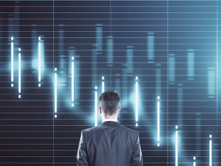 Thinking businessman standing near economic crisis stock charts