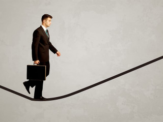 Salesman walking on rope in grey space