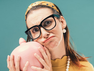 Disappointed woman holding a money box with her savings