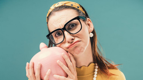 Disappointed woman holding a money box with her savings