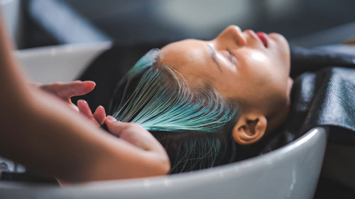 professional hairdresser woman are washing client hair in beauty salon, female head treatment and health care concept, person clean a hair by using water and shampoo to fashion hair care coiffure