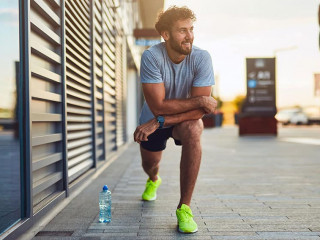 Young man exercising / stretching in urban area.