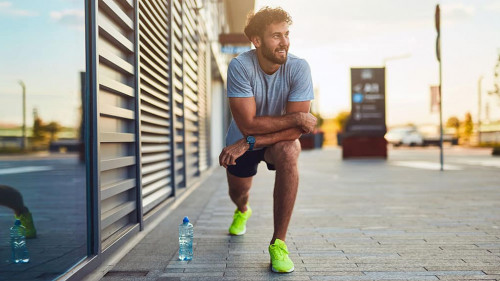 Young man exercising / stretching in urban area.