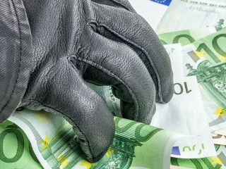 Dieb mit Lederhandschuh greift nach Geldscheinen