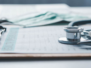 Stethoscope and calculator placed on health insurance documents,