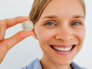 Closeup of Smiling Woman Holding One Euro Coin