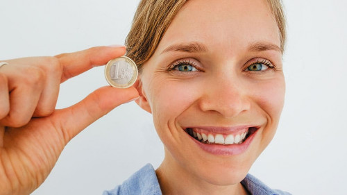 Closeup of Smiling Woman Holding One Euro Coin