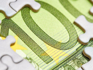 Euro puzzle, business concept of solution. One hundred euro bill and puzzle pieces. Closeup, selective focus