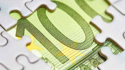 Euro puzzle, business concept of solution. One hundred euro bill and puzzle pieces. Closeup, selective focus