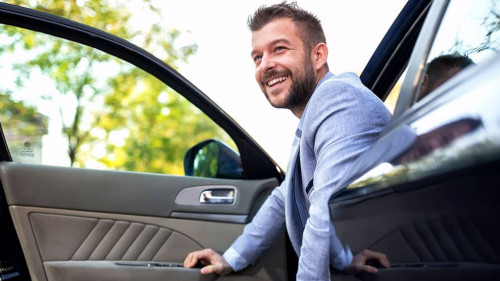 Smiling man exiting his vehicle