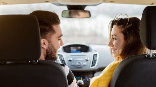 Rear view in a car of beautiful young happy love couple looking