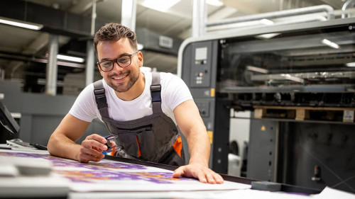 Print house worker controlling printing process quality and chec