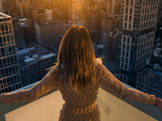 Rich woman enjoy the sunset standing on the balcony at luxury ap