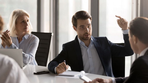 Serious businesspeople discussing new project sitting at desk in