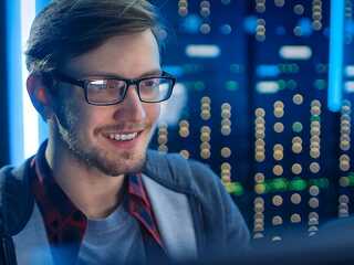 Portrait of Smart SmilingFocused Young Man Wearing Glasses Worki