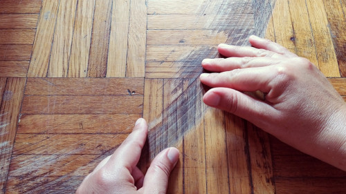 Old scratched surface of hardwood flooring in need of maintenance. parquet ruined by scratches made by prolonged use of chair.