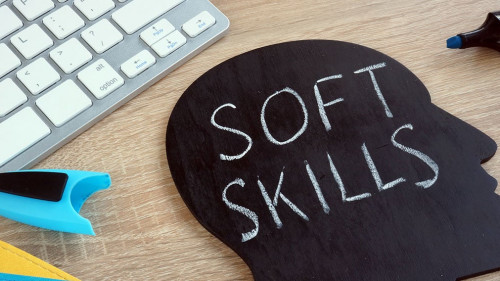 Soft skills written on a blackboard with the shape of a head.