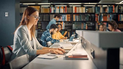 University Library: Talented Caucasian Girl Sitting at the Desk,