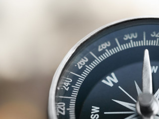 Close-up brass antique compass on marble table